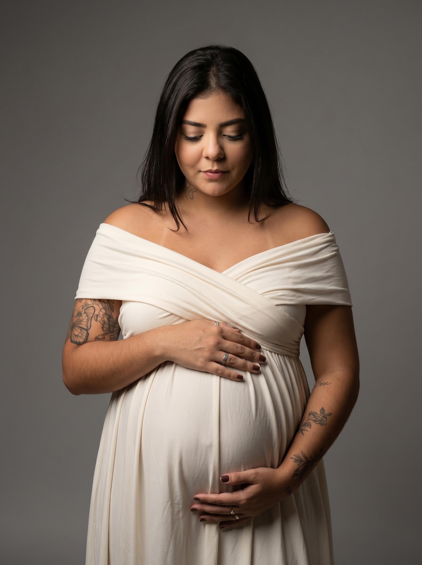 Gestante segurando a e olhando para a barriga em contemplação materna.